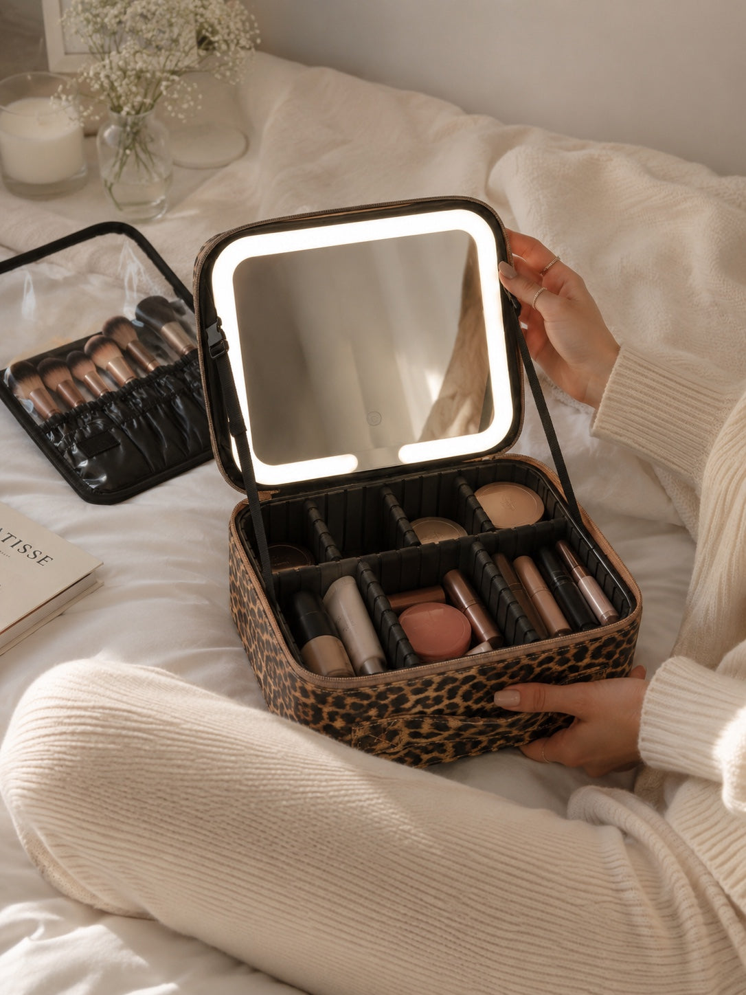 adwomen holds a makeup bag on a bed